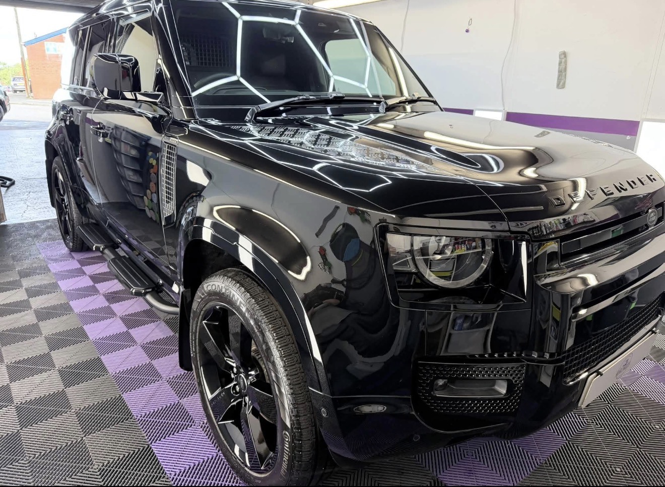 Black Land Rover Defender in Royle Valet's purple-lit studio